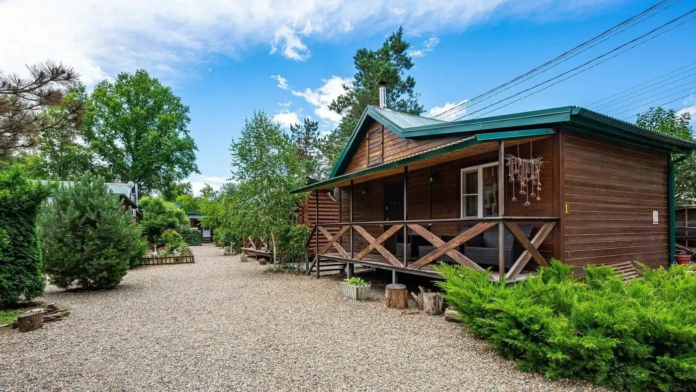Бревенчатый домик с крыльцом на гравийной дорожке